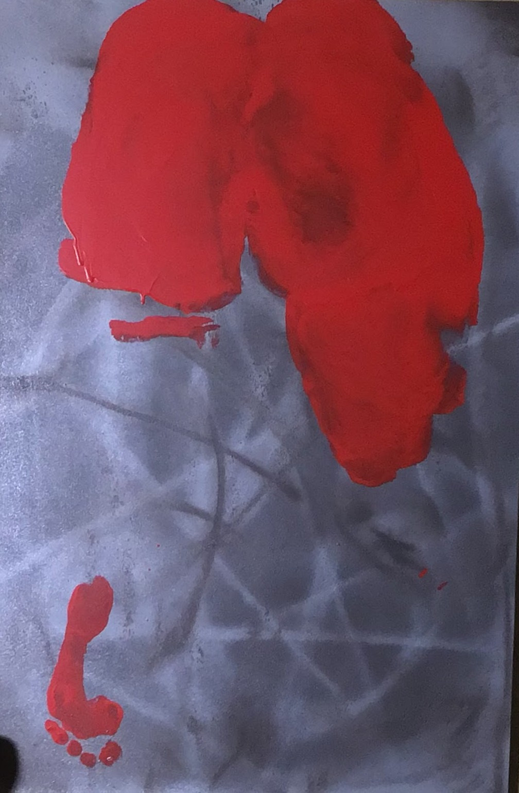 A red body impression on a gray ground with crossing pale marks