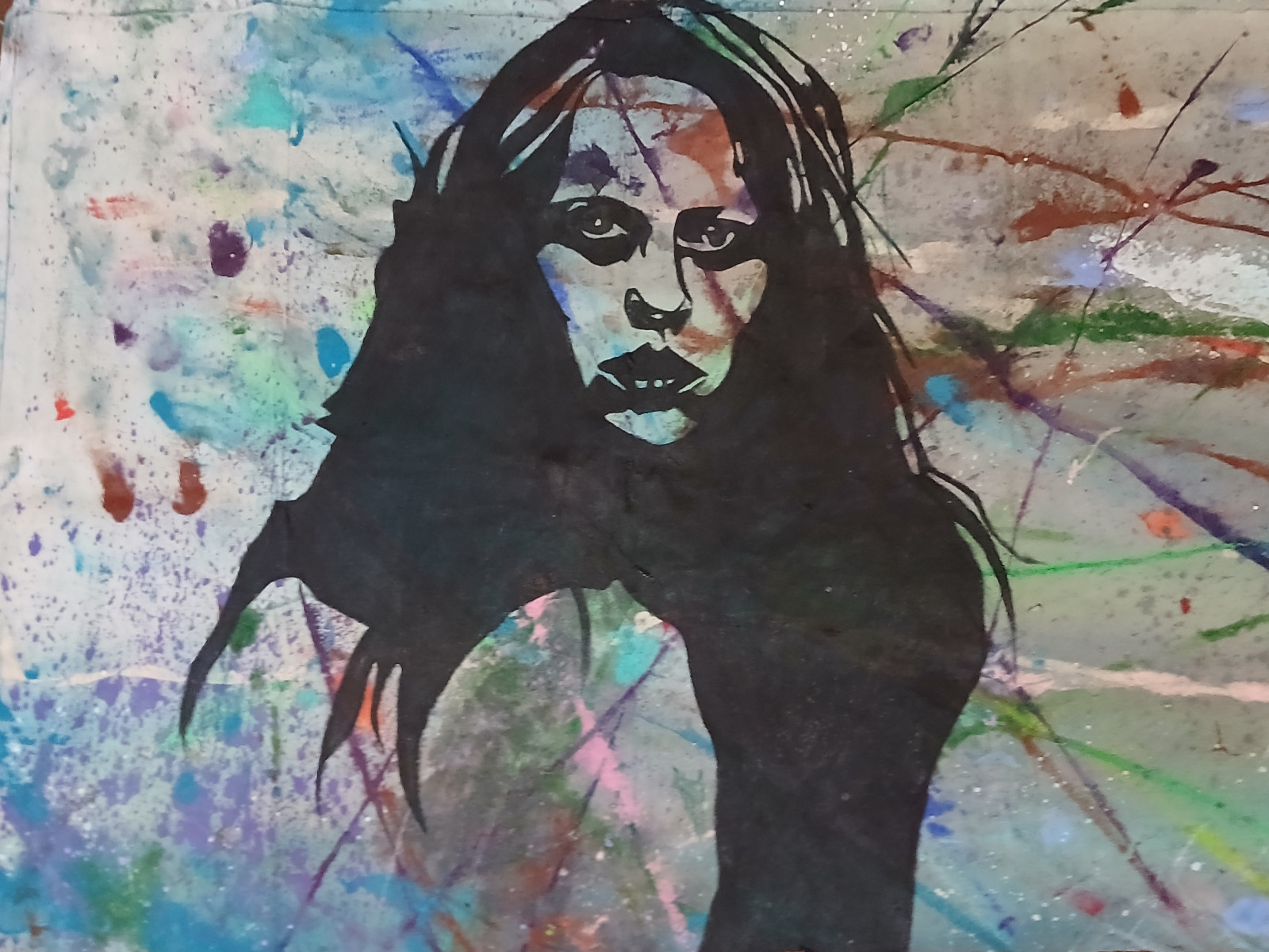 Long-haired woman looking over her shoulder against blue and green paint splashes