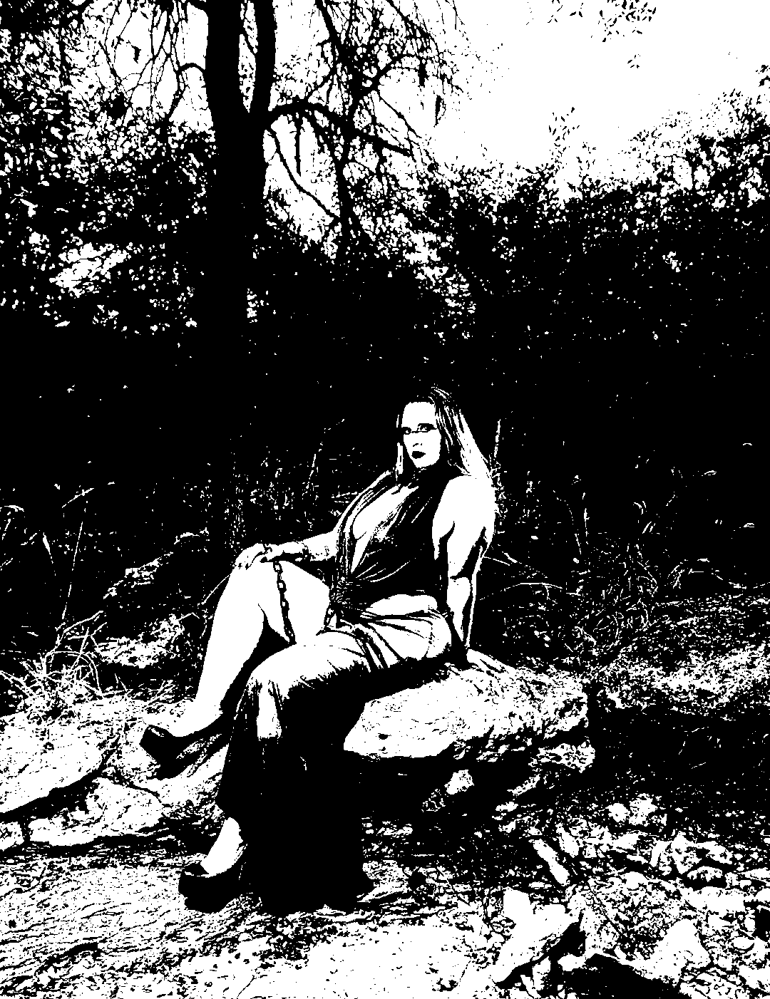 Seated figure on a rock surrounded by trees