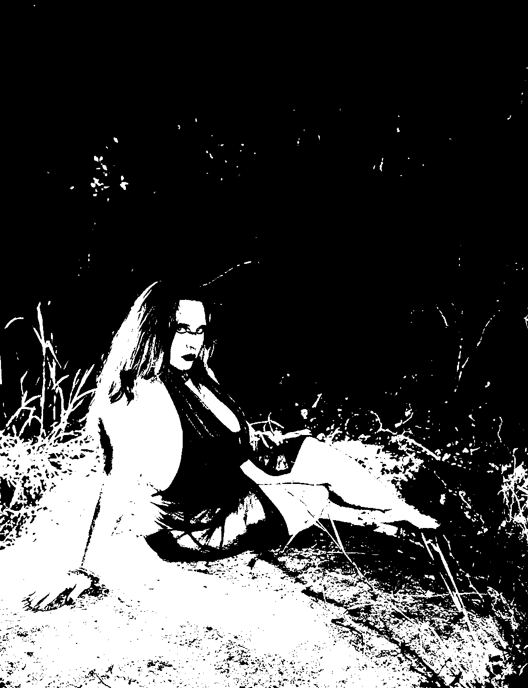 Threshold portrait of a figure reclining on a sunlit rock